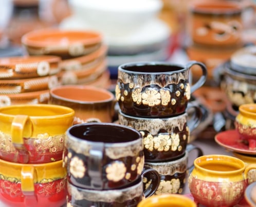 stacks of colourful pottery in a market