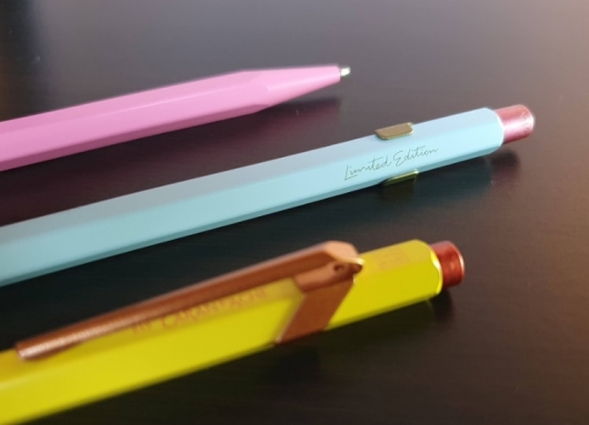 three pens on a table