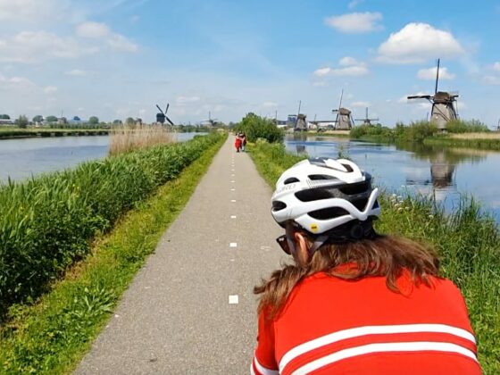 cyclists cycling between canals and windmills in Zaanse Schans
