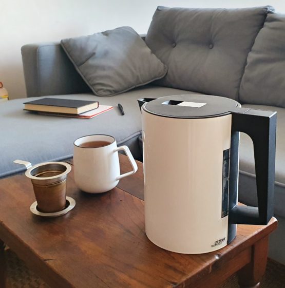 german made white kettle next to a sofa